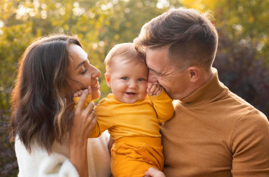 famille heureuse avec un enfant dans les bras