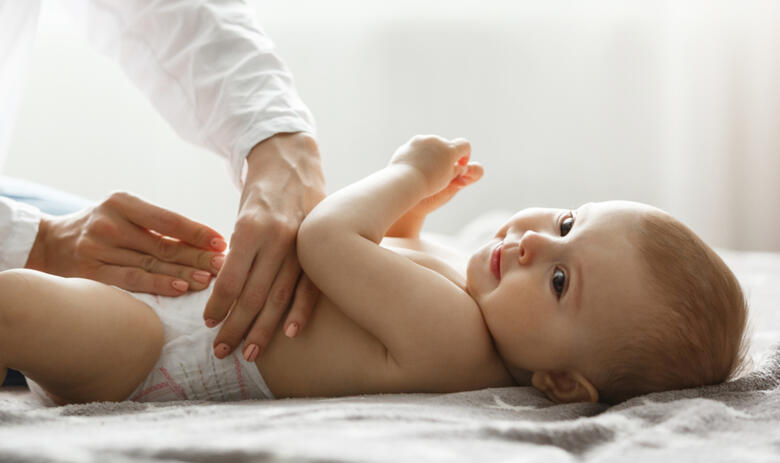 maman change la couche de bébé